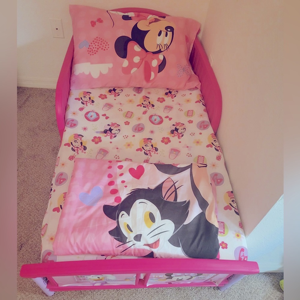 Toddler Crib with a pillow, pillow sheet, mattress and sheet and a blanket.
